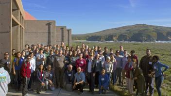 Group photo of all attendees posed in front of a coastal mountain