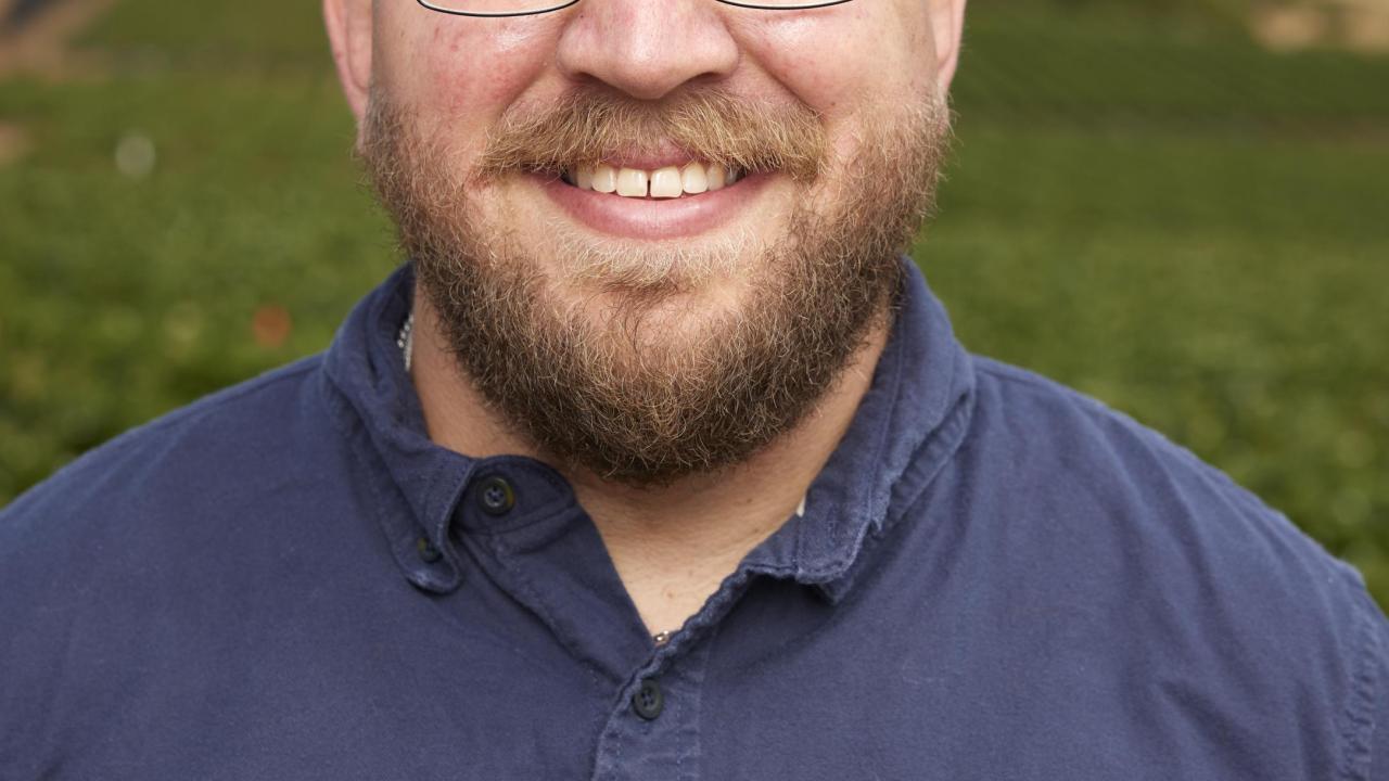 Portrait of Mitchell Feldmann against a background of strawberry fields