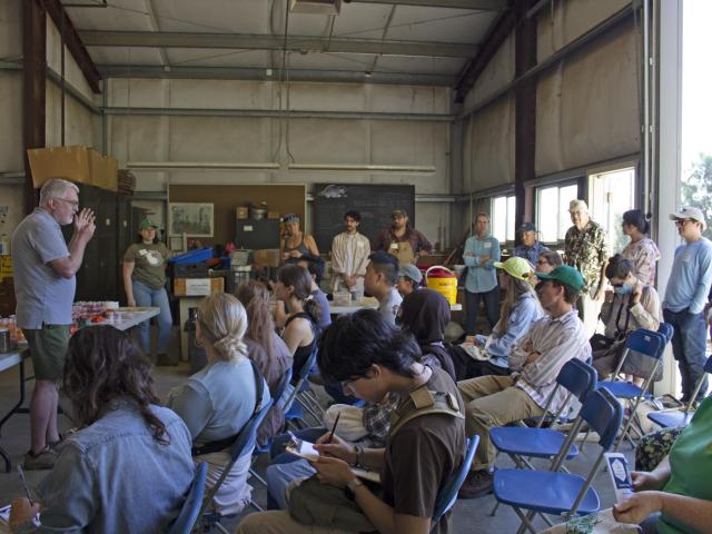 Open house crowd with a speaker and several people in the audience