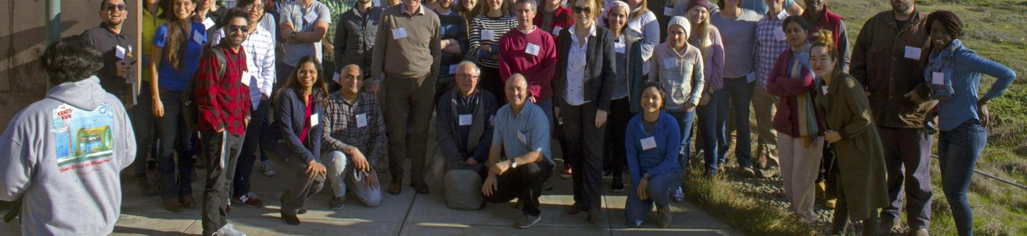 Group photo of all attendees posed in front of a coastal mountain